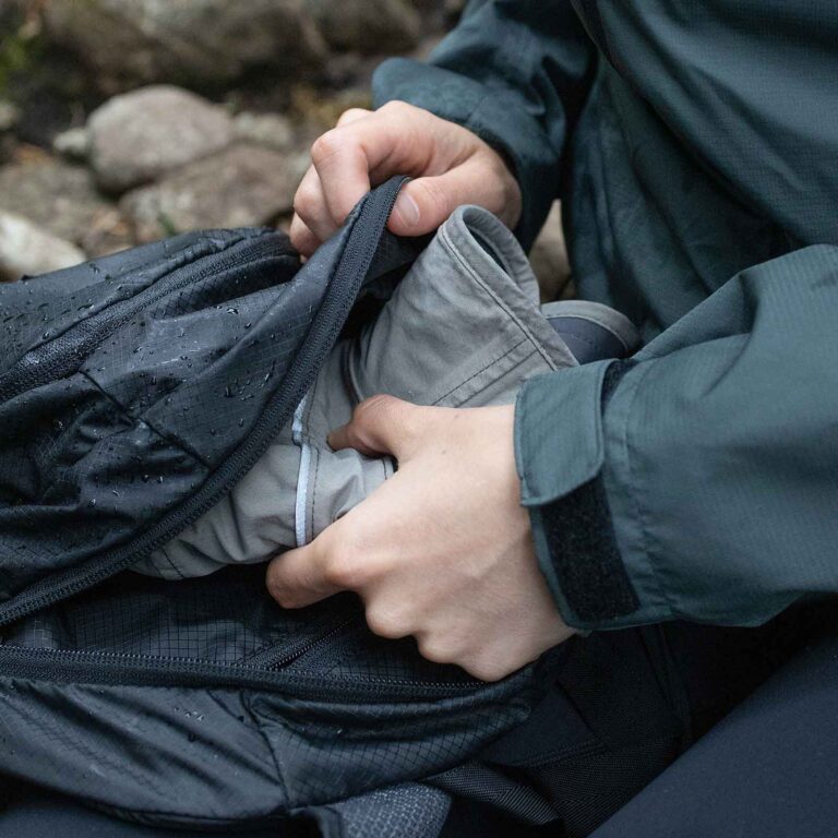 כובע בצבע אפור כהה מקופל לתוך התיק